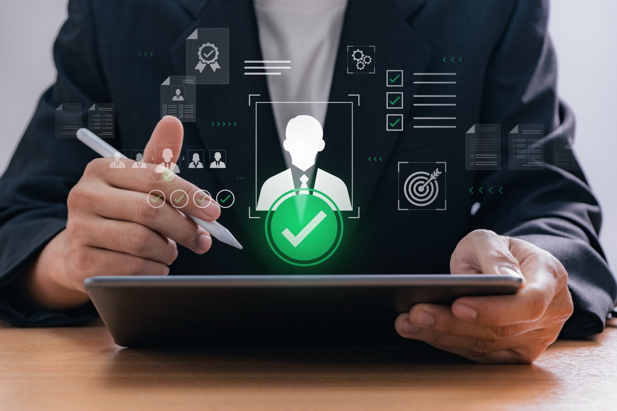 Digital recruitment process with HR manager selecting candidate using tablet in office environment, representing human resource technology and technical team augmentation provider in modern business workflow.